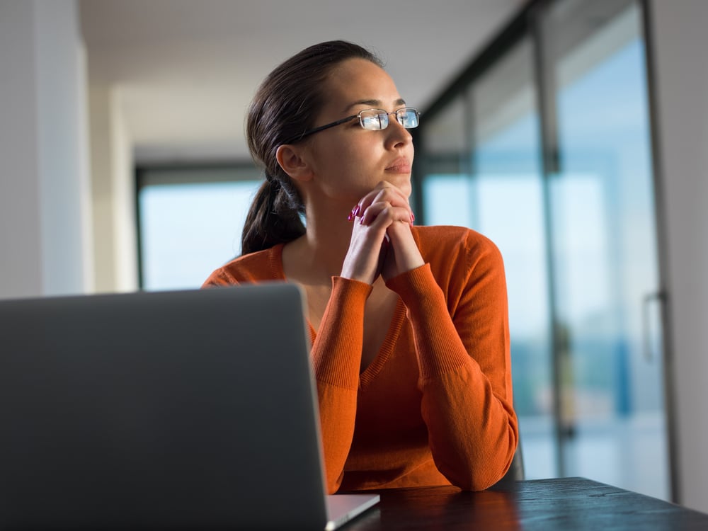 Businesswoman weighing decision between Acumatica or NetSuite ERP solutions.