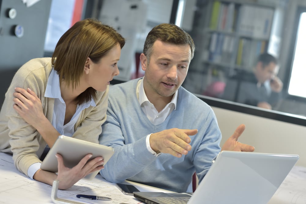 Business people in office working on laptop and tablet with Acumatica
