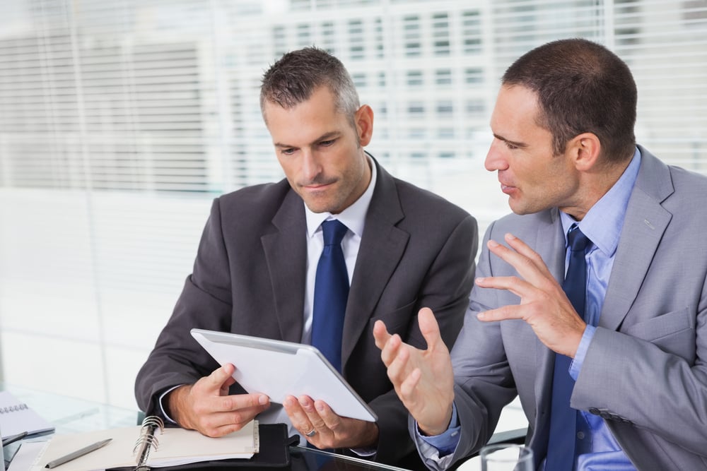 Businessmen analyzing data and reviews of Shopify Plus vs BigCommerce B2B Edition.