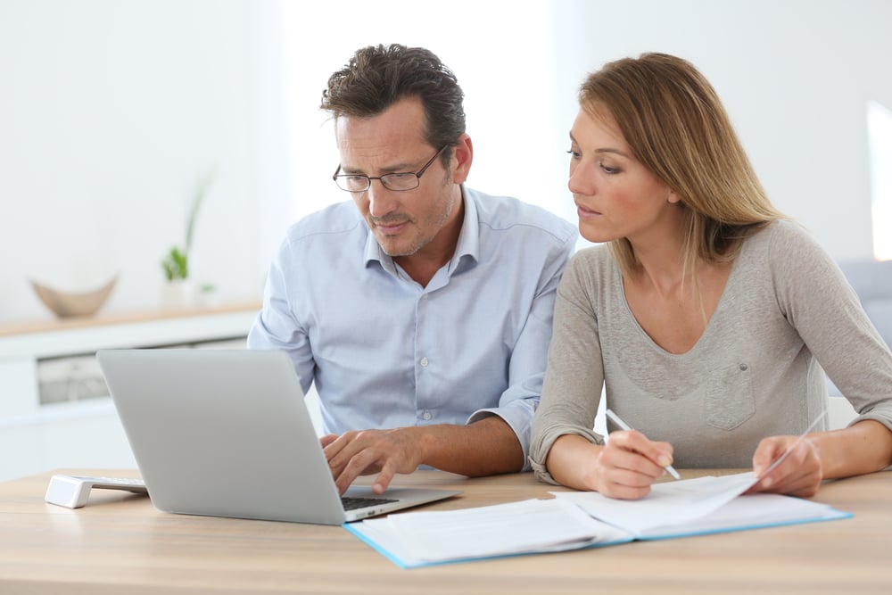 Businesspeople frantically analyzing multiple QuickBooks financial statements.