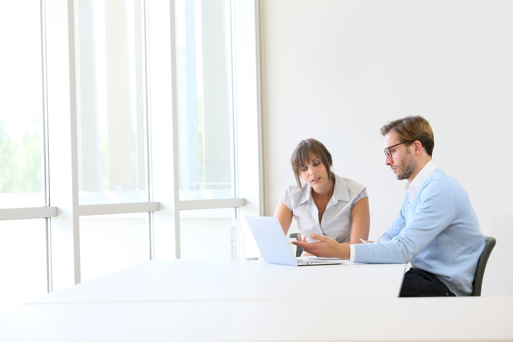 Coworkers troubleshooting issues within QuickBooks.
